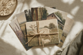 Stack of six botanical farm postcards tied with twine on cream linen